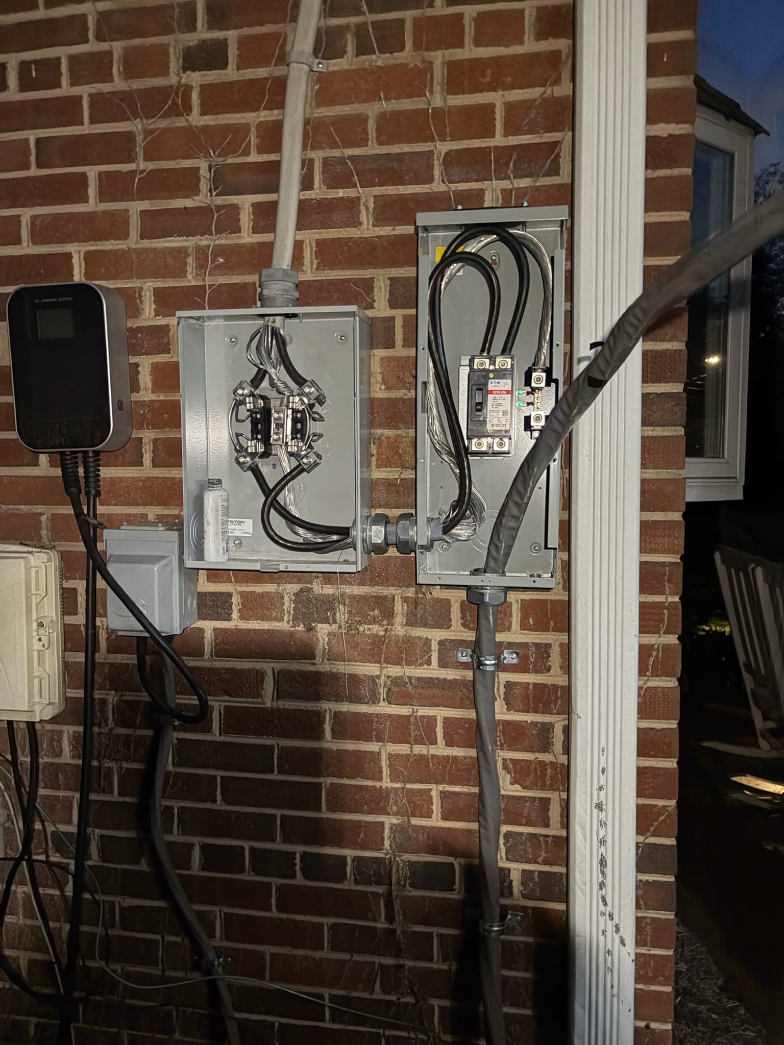 An outdoor electric meter base mounted on the exterior wall of a home