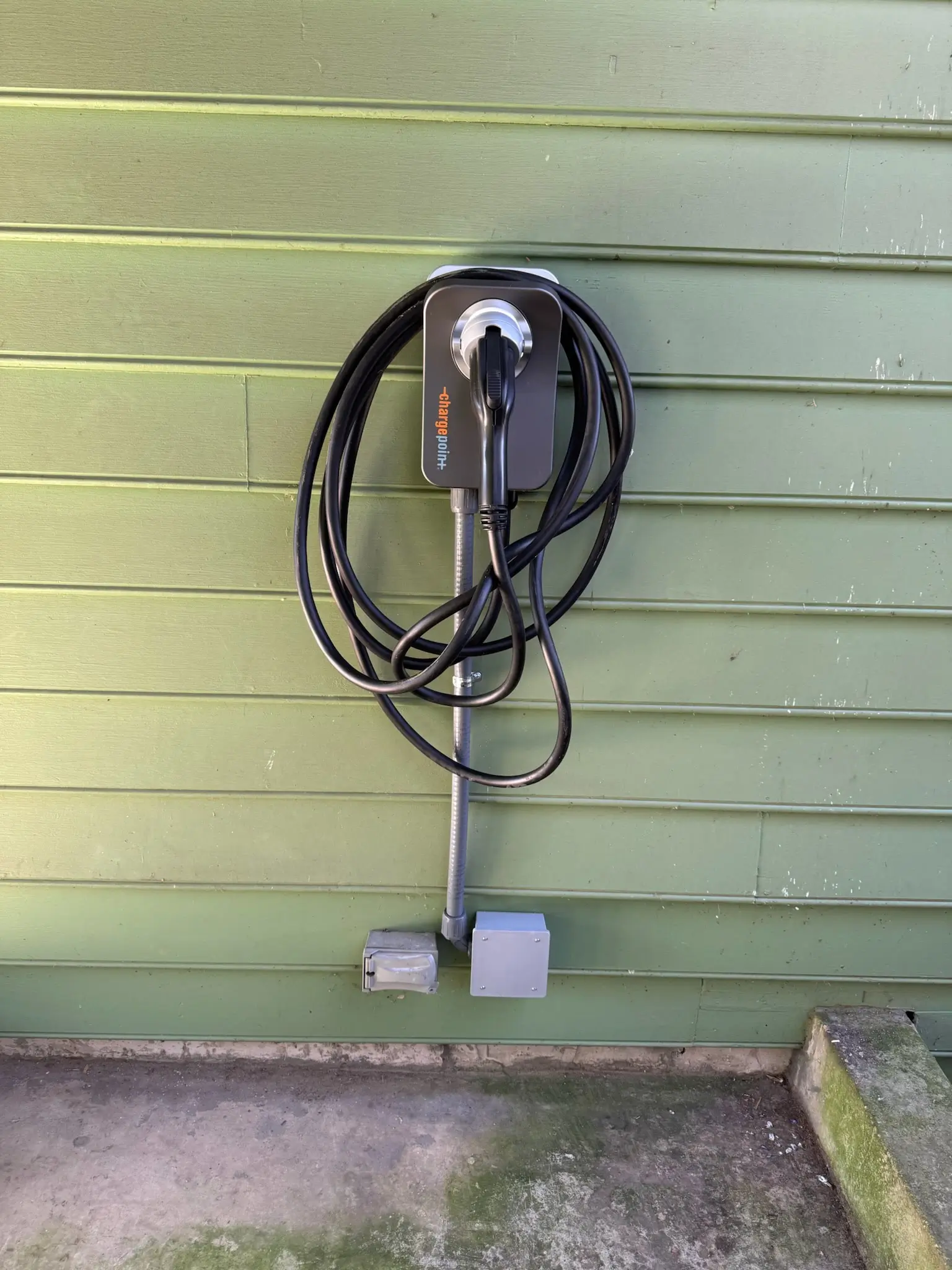 A ChargePoint home electric vehicle charger mounted on a wall
